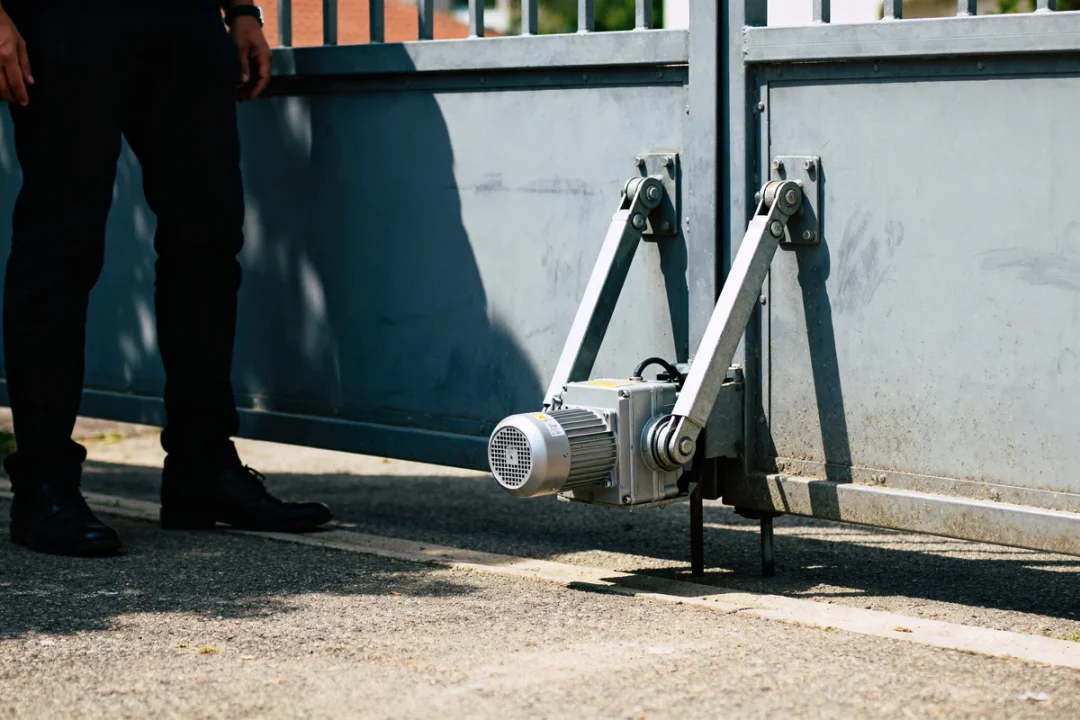 Moteur came portail battant installé sur portail métallique avec homme à proximité