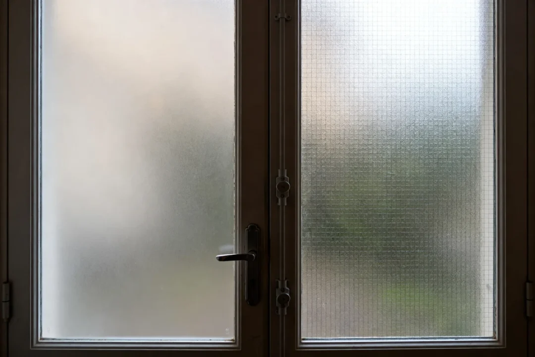 Porte d'entrée semi vitrée avec vitrage dépoli et serrure métallique apparente