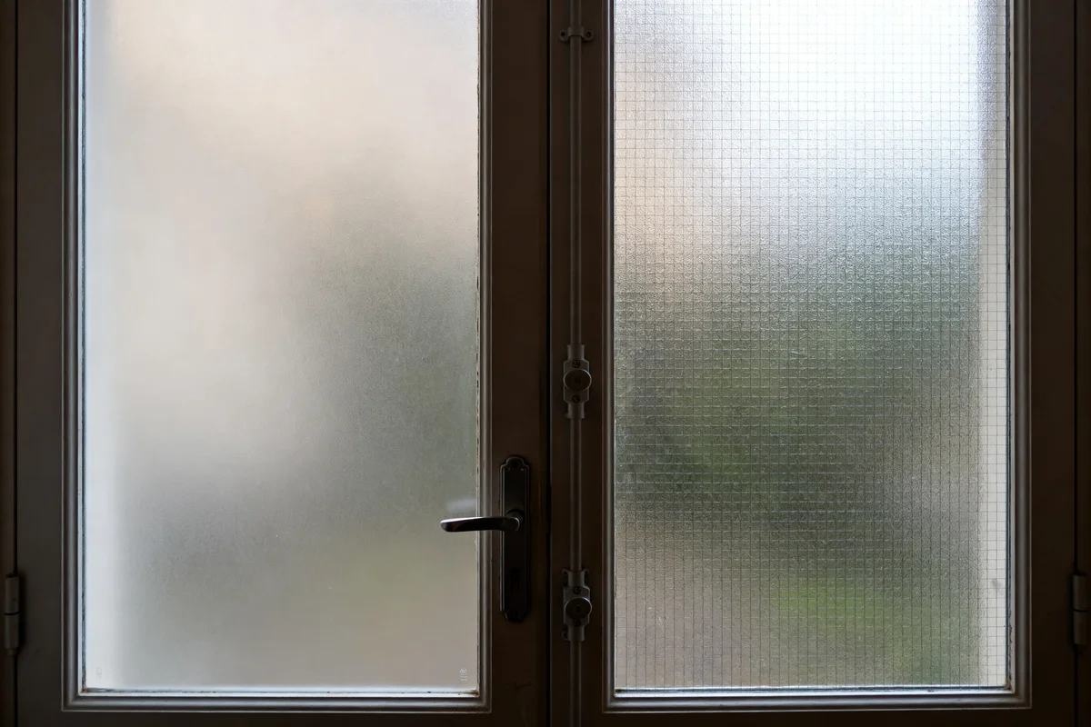 Porte d'entrée semi vitrée avec vitrage dépoli et serrure métallique apparente