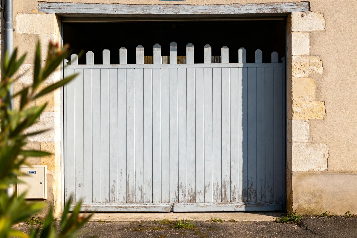 Vieille porte de garage en bois bleu clair sous soleil intégrant prix porte de garage avec portillon